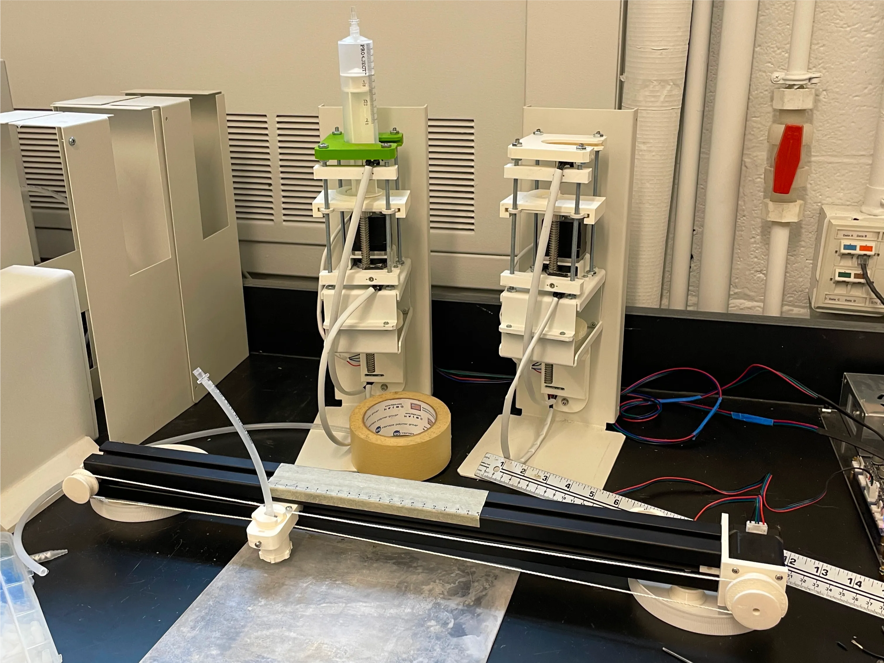 The string is wrapped around a spool connected to a stepper motor which winds/unwinds in order to move the nozzle along the rail